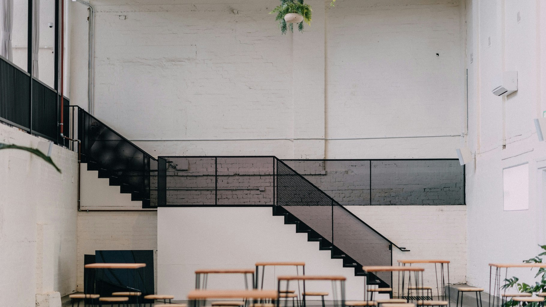White warehouse walls with black staircase.